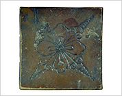 Tile with Carved Flower Design and Iron Glaze