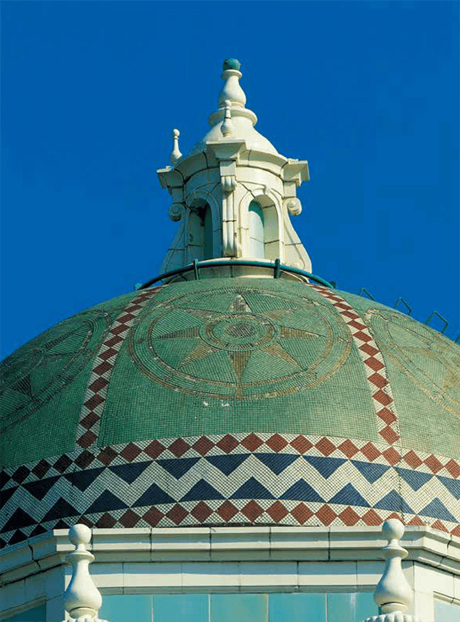 The Spanish-style Shizuoka City Hall building, built in1934, is topped with a terracotta tower and an Islamic-style dome roof. The roof is covered with green and gold mosaic tiles featuring a compass design. The terracotta and mosaic tiles were both produced by Ina Seito (INAX).